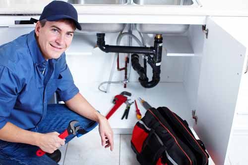 An Illinois Plumber works on a sink